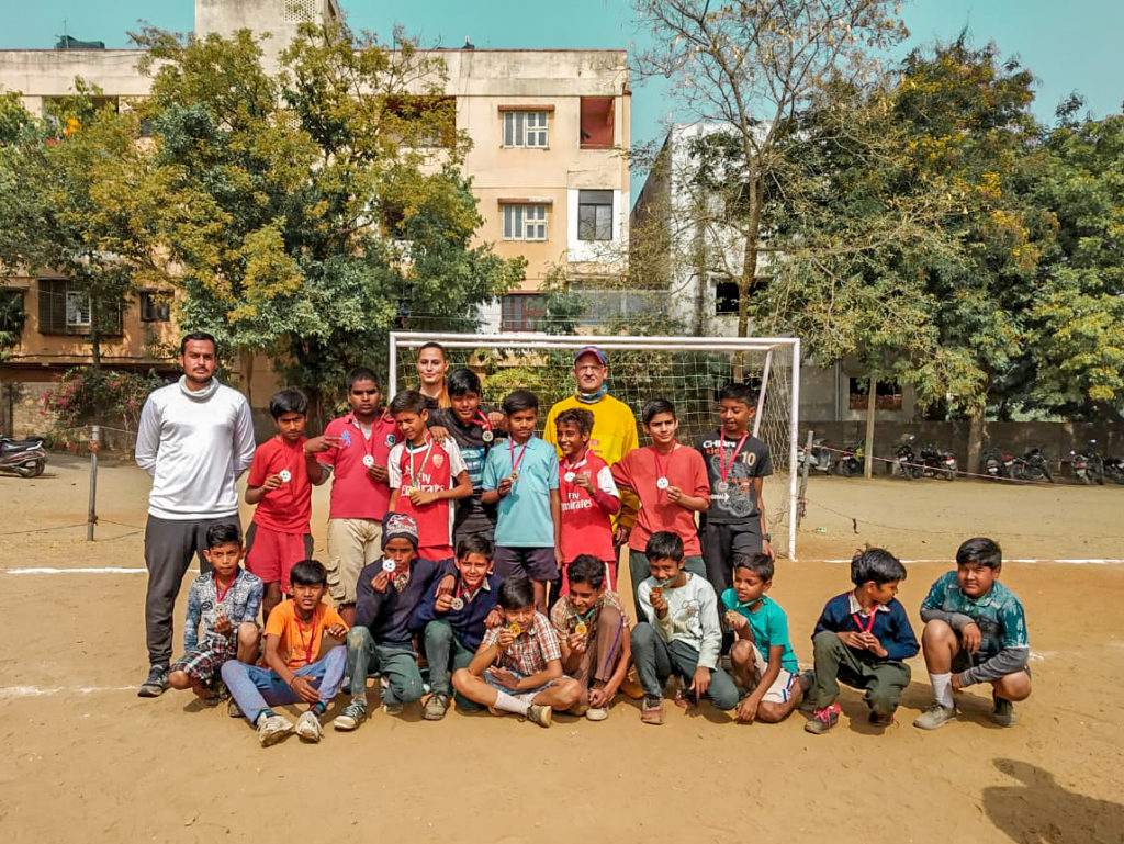 Youth sports team posing for a group photo on a football pitch in India