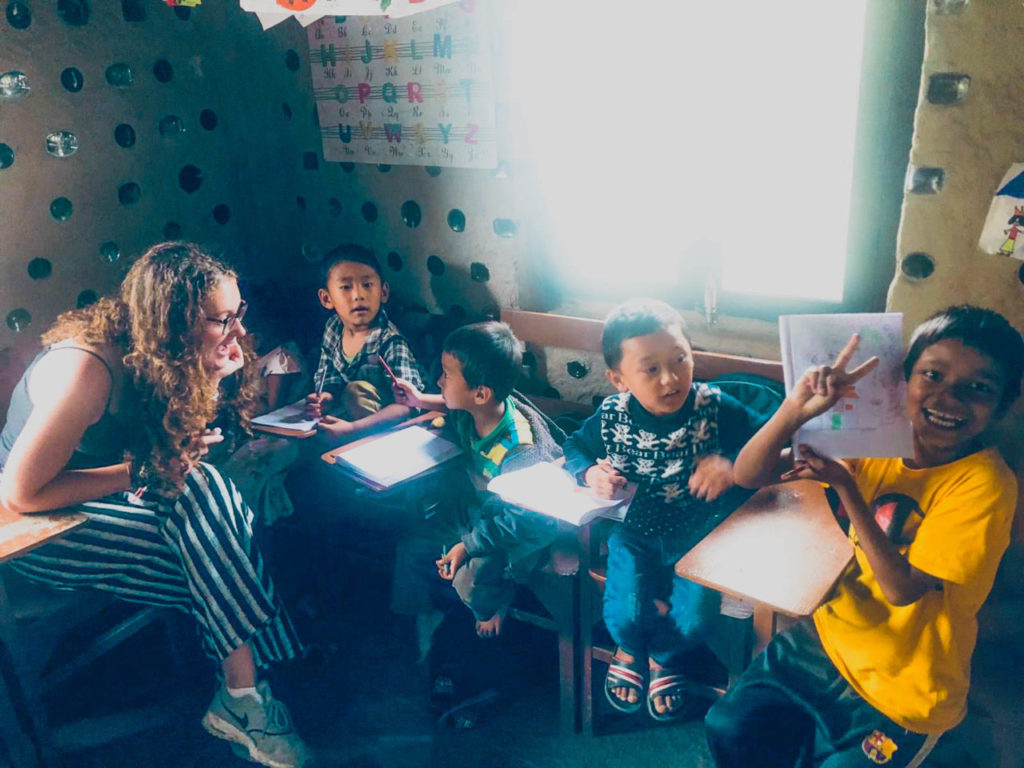 Children and volunteer taking part in a classroom activity in Nepal