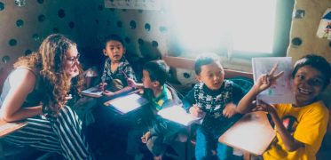 Teacher helping children with lessons in a classroom in Nepal