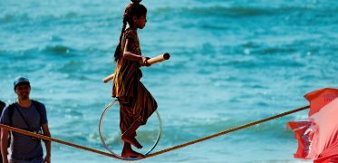 Traditional tightrope walker performing beside the sea in India